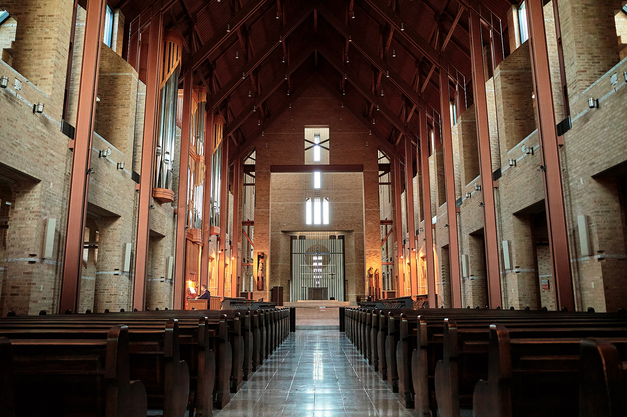 Ricoh GR III SDR JPEG looking down a symmetrical brick church aisle toward bright altar windows.