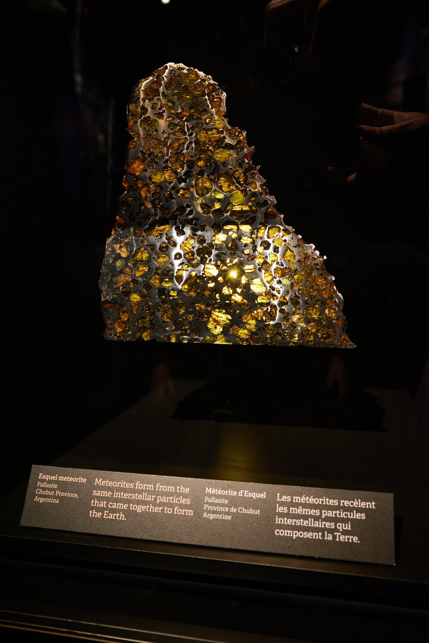 Ultra HDR version of the meteorite with brighter embedded crystals against the black display.