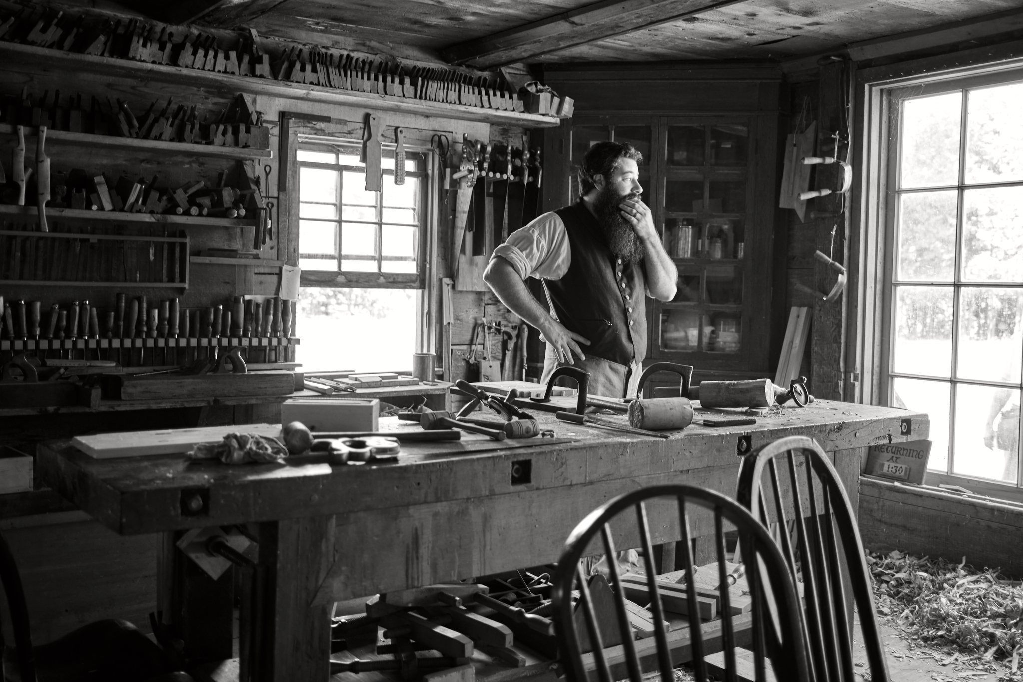 ToneLatch Ultra HDR export of the same monochrome woodshop portrait with brighter window highlights.
